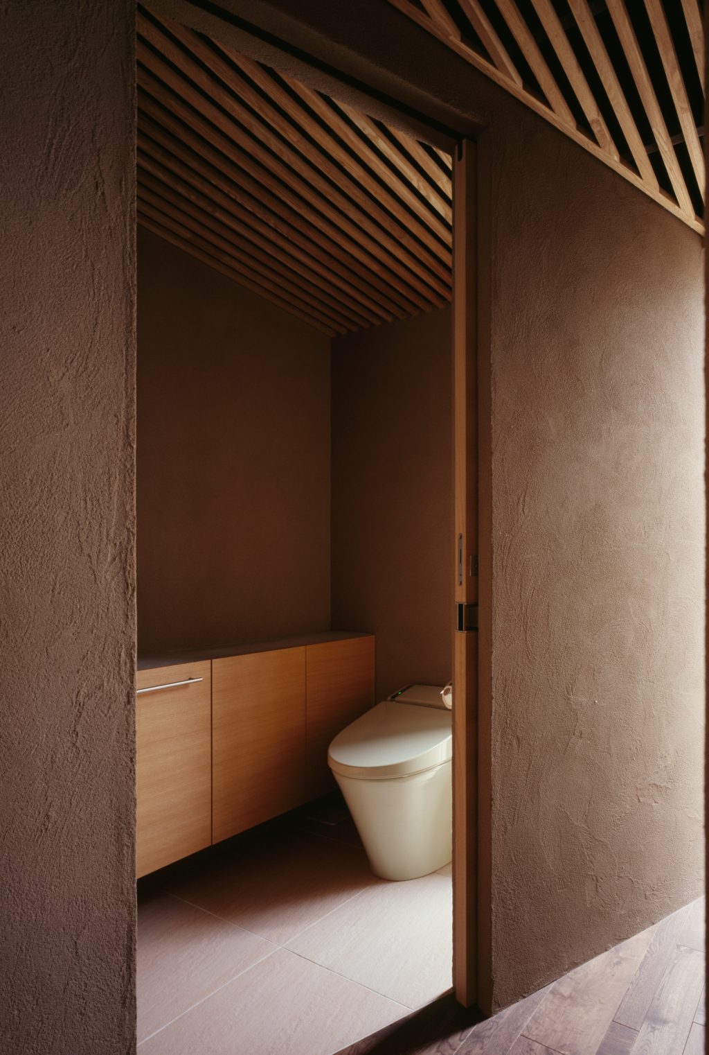 トイレカウンター収納。カウンター天板はモルタル仕上げとし、カウンター下の扉を開けると収納となっています。