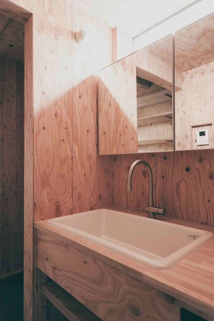 洗面は上部に設けた窓から　北側の穏やかな光が1日中入ります。陶器シンクは　TOTO　SK106。子育て世代のご家族には　大きなシンクが使い勝手よくとても便利。水栓は　ツールボックスのホース水栓。鏡は　ミラタップ製収納ボックス付き鏡。内部にはコンセントを施し　電動歯ブラシやひげ剃りの充電ができます。